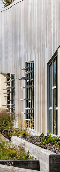 Raised garden beds outline the side of the building.