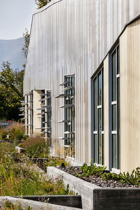 Raised garden beds outline the side of the building. 