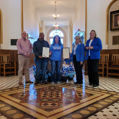 Saline County Commission, City of Marshall Mayor and Department of Social Services member standing with proclamations in Courthouse rotunda