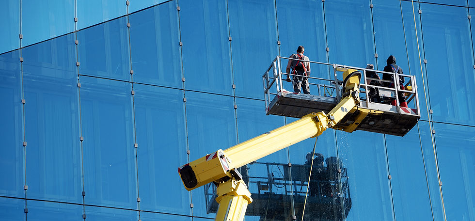Cleaner worker using a cherry picker to clean a glas facade of a contemporary office build