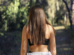 Mujer de espaldas caminando por el bosque