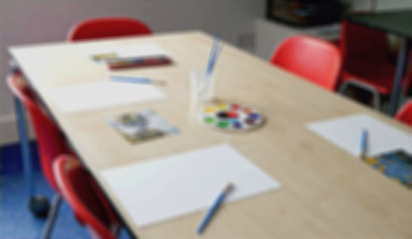 A blurred view of a school table with a range of chairs