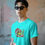 Thumbnail: Asian man wearing turquoise Grinch Christmas t-shirt and sunglasses
