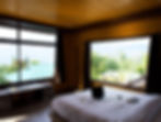 Premium room at Emaho Boutique Resort with expansive windows offering breathtaking views of the surrounding greenery and moun