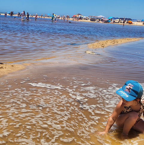 Child playing in shallow water at the bay