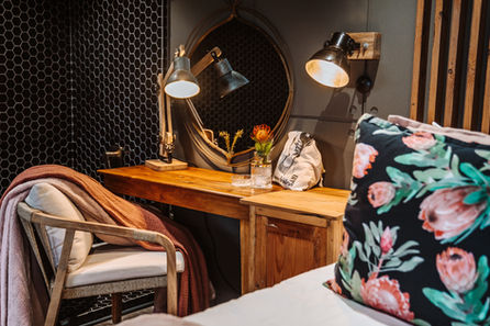 Bedroom desk with lamps, mirror, and floral pillow