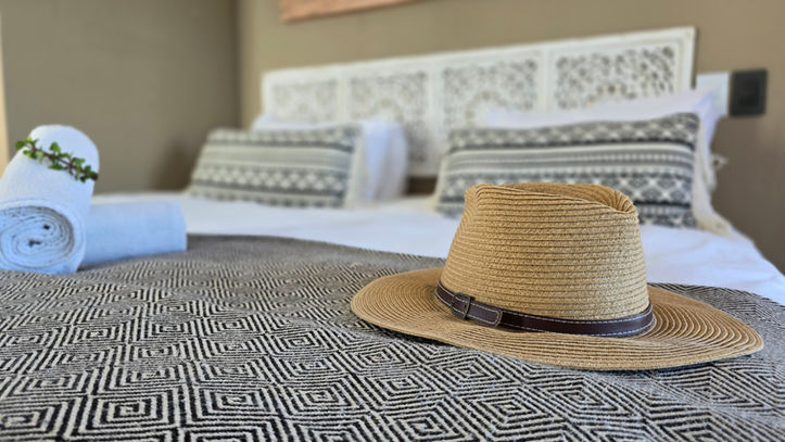 Straw hat on a patterned bed in a cabin