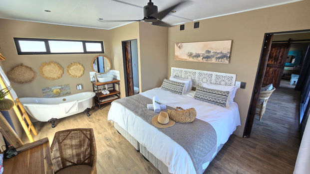 Bedroom in Eco Cabin 1 with king-size bed and freestanding bathtub
