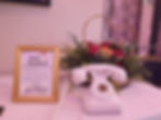 A white audio guestbook phone next to a gold frame stating happy anniverary and instructing guests on how to use the phone.