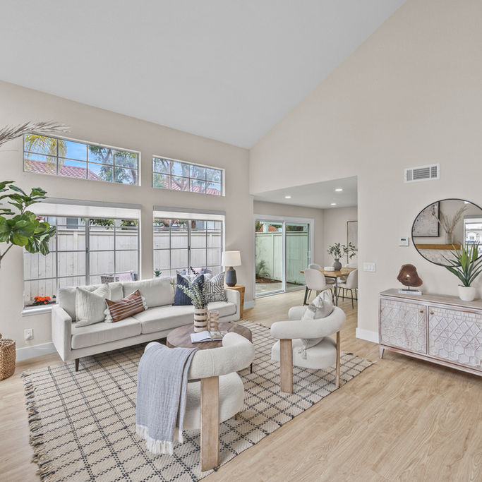 open concept living space with high ceilings and round mirror by luxury home staging near me