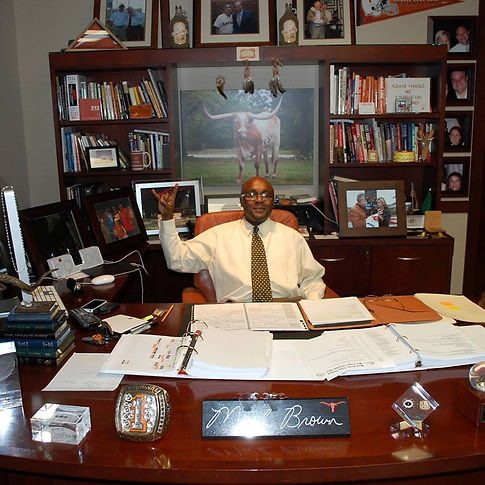 Chef Kenneth Rector Jr., sitting behind Mac Brown's desk at UT Texas
