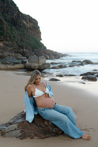 pregnant girl on rock at the beach