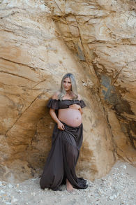 pregnant lady leaning against a rock
