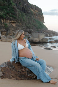 pregnant lady sitting on a rock