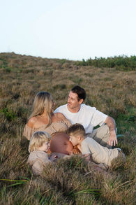 a family sitting in tall grass looking at each other