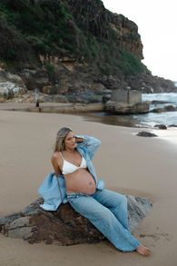 pregnant lady sitting on a rock