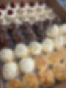 Rows of chocolate and vanilla cheesecake cupcakes with pearl sugar beads on top of the icing. 