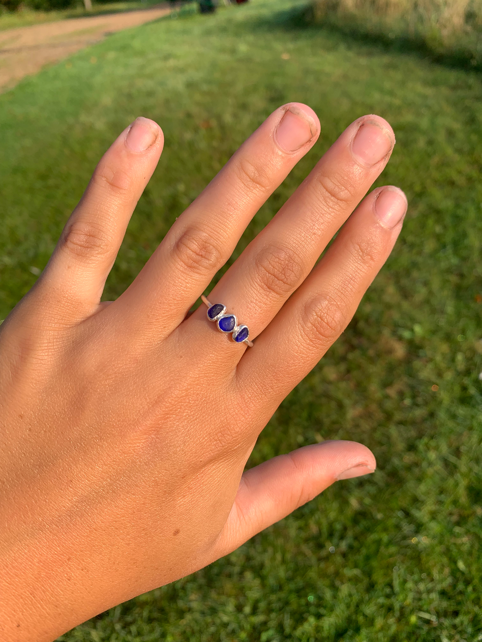 Custom sea glass ring with three small dark blue stones.