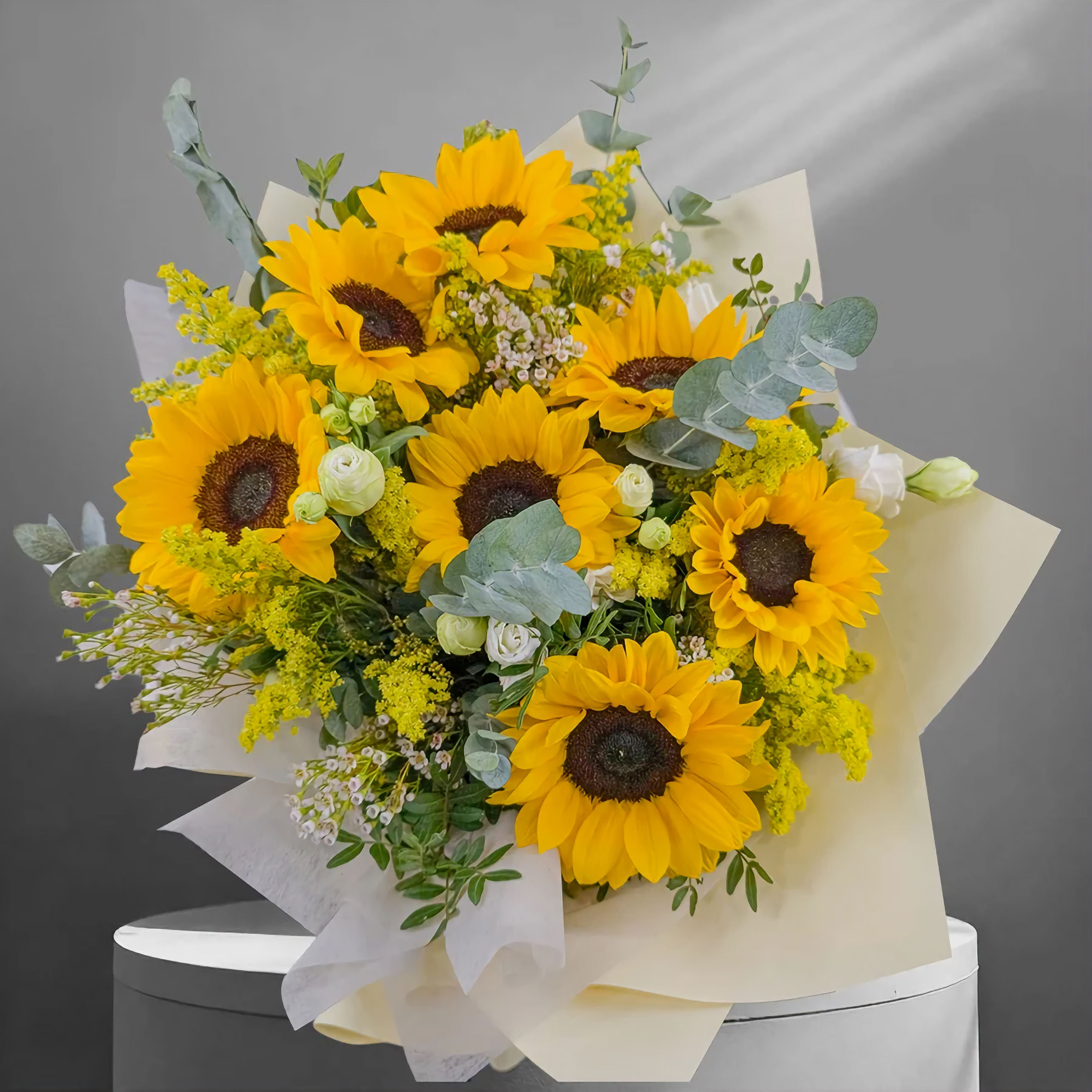 Cheerful bouquet of seven fresh sunflowers with greenery, perfect for birthdays or gifting happiness