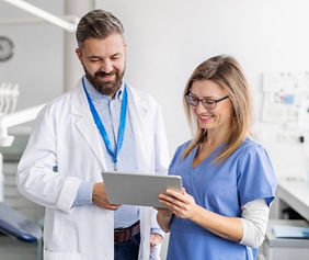 A dedicated Aceso Dental Lab customer support manager collaborating with a dental professional, reviewing a digital case on a tablet to provide technical guidance.