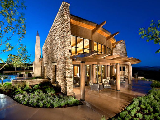 A luxury modern landsacape in Highlands Ranch featuring a high-end outdoor living space with a custom stone fireplace, integrated lighting