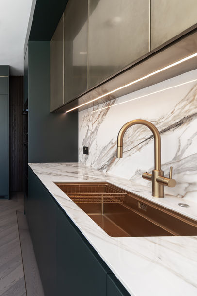 Undermount sink detail with brass tap and marble