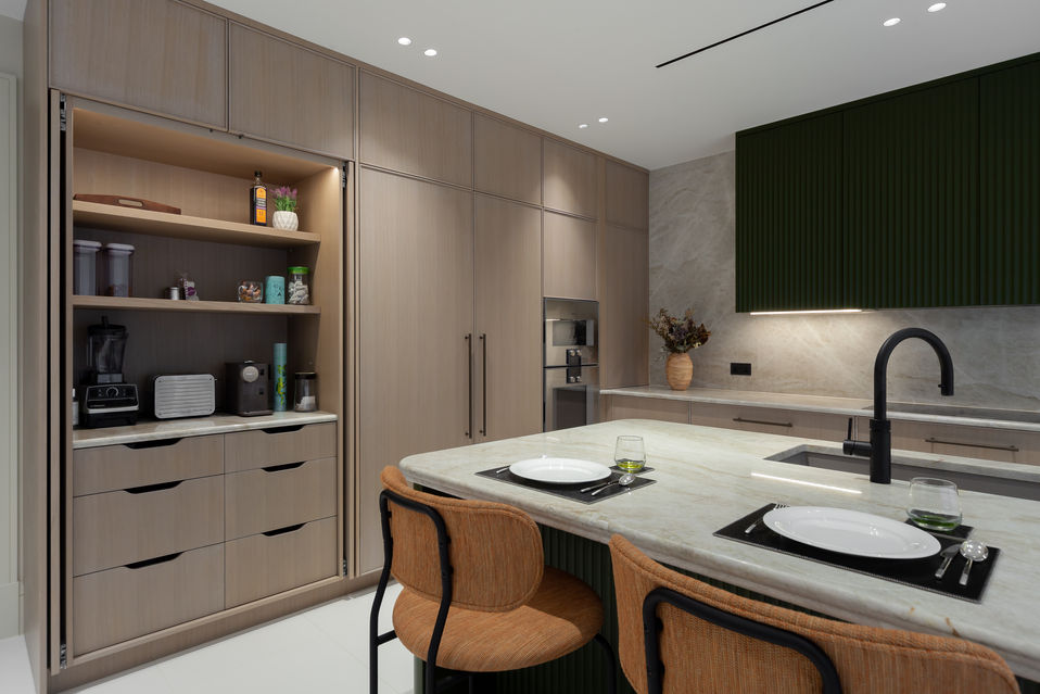 Kitchen and dining angle showing island, open shelving and warm timber cabinetry on Bishops Avenue, London.