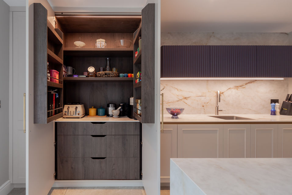 Open pantry cupboard showing shelves and storage inside bespoke kitchen units