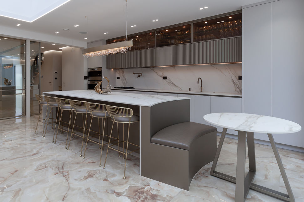 Open-plan kitchen with marble-look flooring, island stools, and built-in banquette seating.