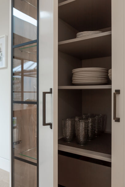 Pull-out pantry storage with shelves inside a tall kitchen unit in Fulham, West London.