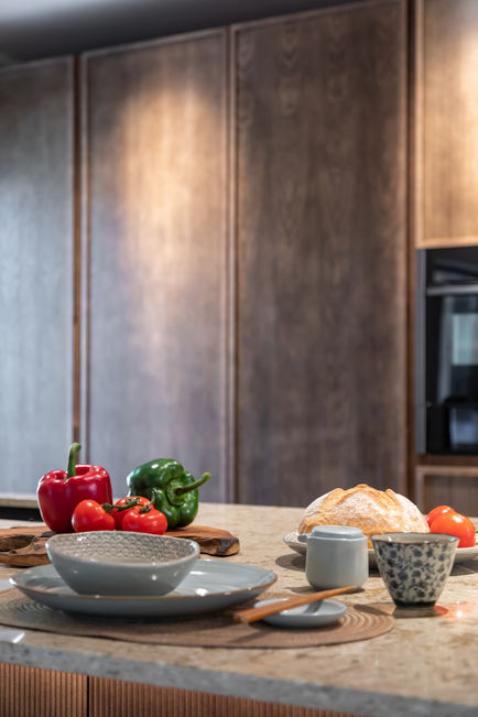 Close-up of stone kitchen worktop with fruit styling and wood cabinetry backdrop