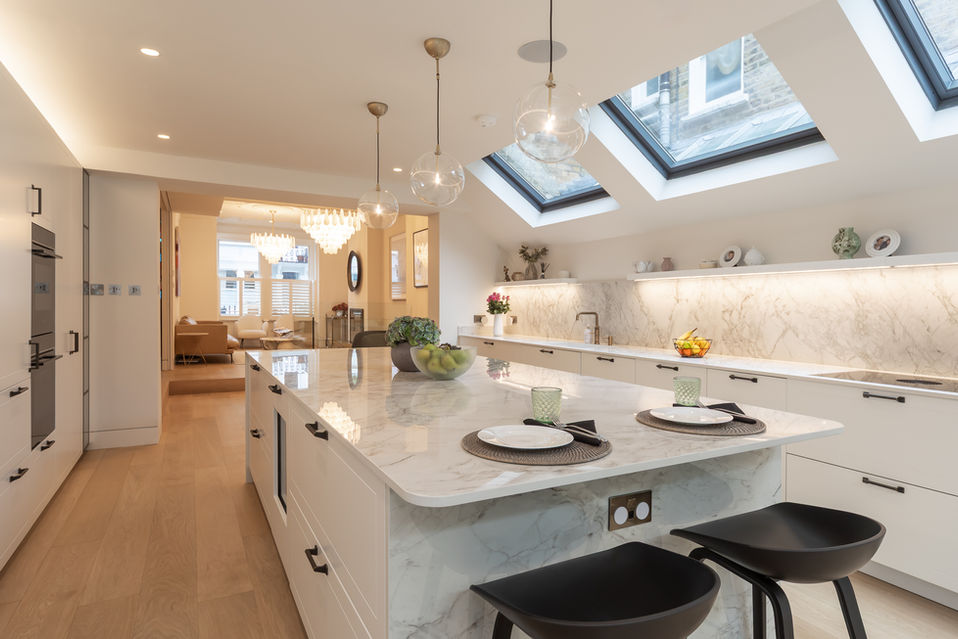 Modern kitchen with island seating, pendant lights and skylights in Fulham, West London.