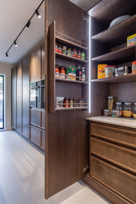 Open walk-in pantry with shelves, drawers and organised kitchen storage in modern cabinetry