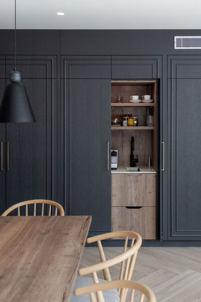 Dining corner with timber table and dark cabinetry, highlighting clean joinery lines, Queen’s Park, London.