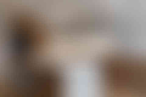 Contemporary kitchen with white waterfall island and warm timber cabinetry, photographed in London.