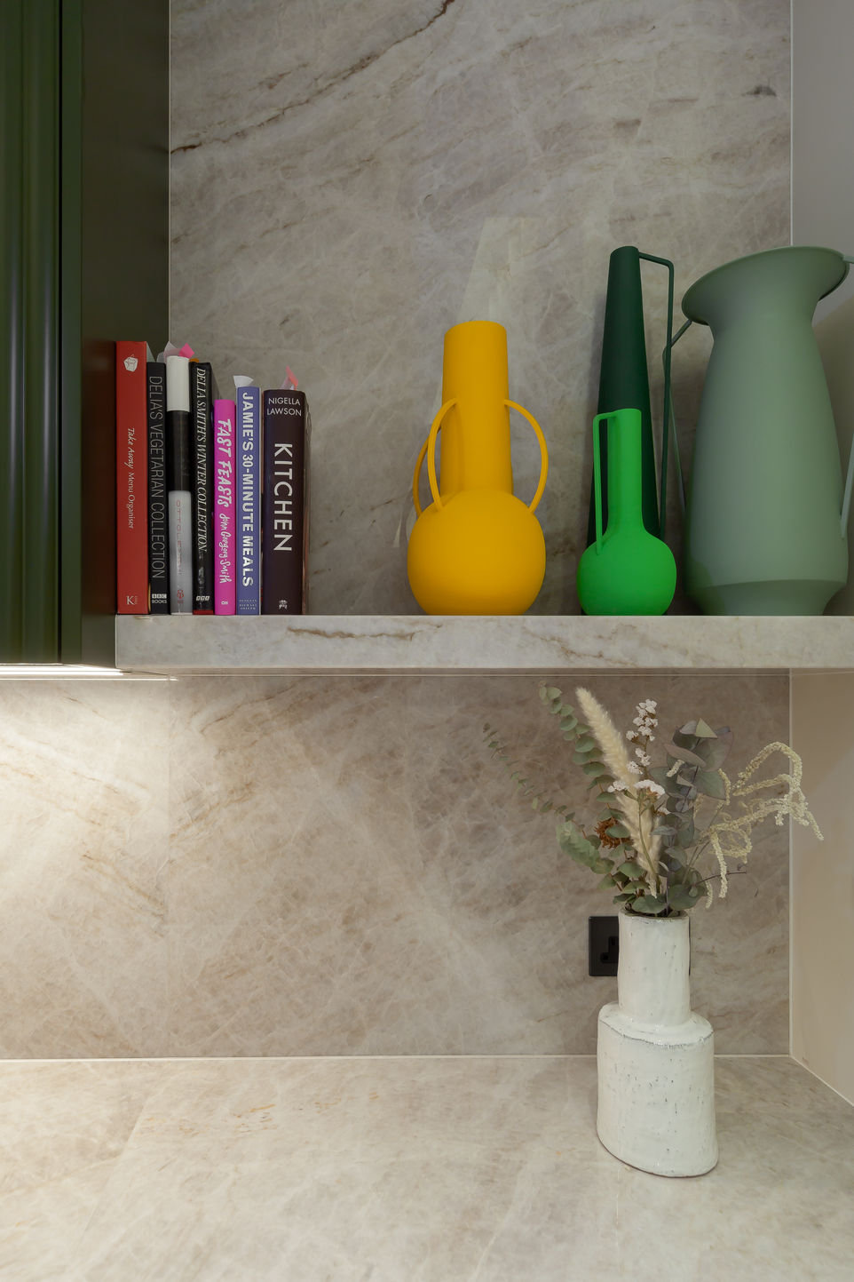 Styled open shelf with books, vases and small decor items.