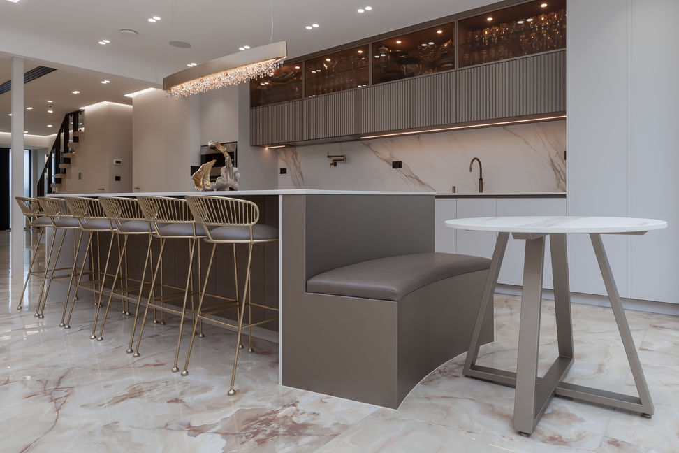Lifestyle view of the kitchen-dining area with banquette seating and island stools in Stamford Hill, London.