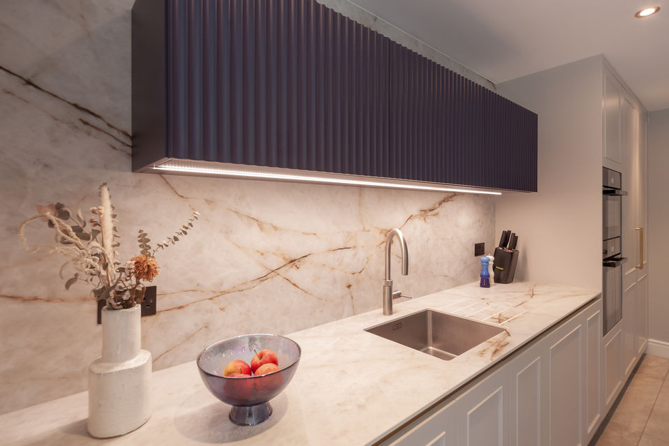 Kitchen worktop with integrated sink, marble splashback and soft under-cabinet lighting