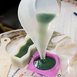 Melted soap being poured into a mold as part of a guided sensory wellness lab experience.