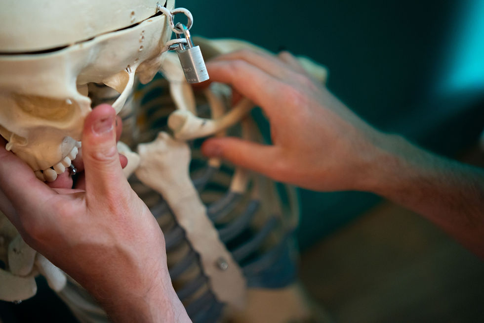 Een man onderzoekt de schedel van een skelet dat gesloten is met een cijferslot