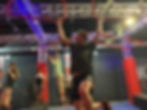 A man swinging between two high bars at Ninja Warrior UK Watford
