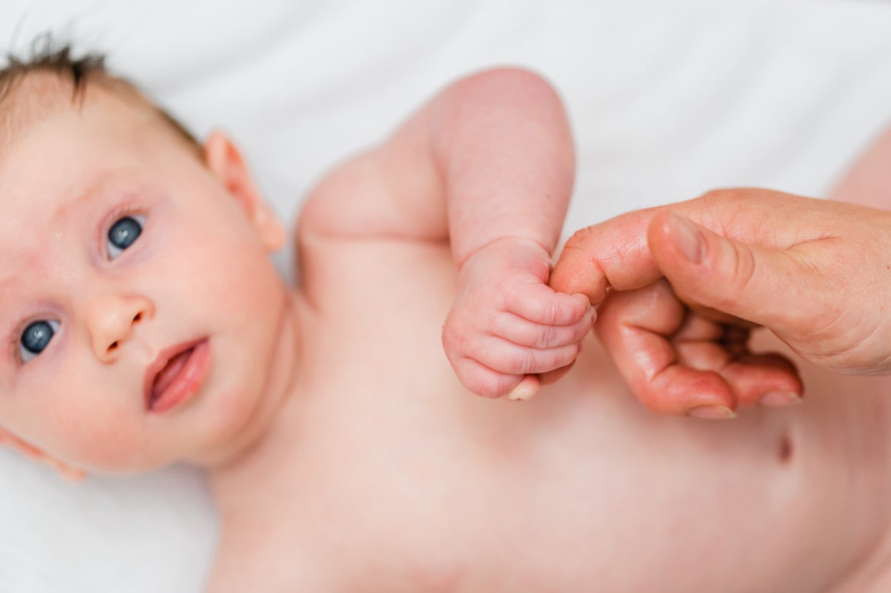 A newborn baby with blue eyes looking directly at the camera
