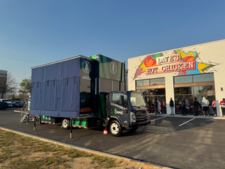 Evening crowd enjoying grand opening golf activation outside Dave’s Hot Chicken in Augusta
