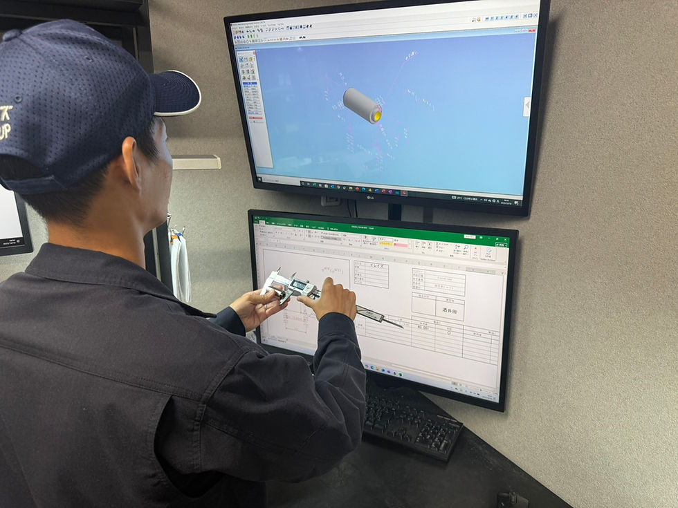 図面と金属加工品を確認するイレイズグループの社員