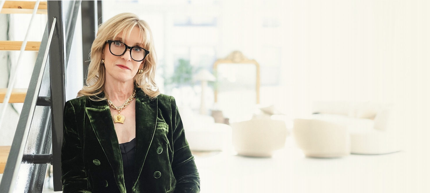 Woman with glasses in a green velvet blazer near stairs