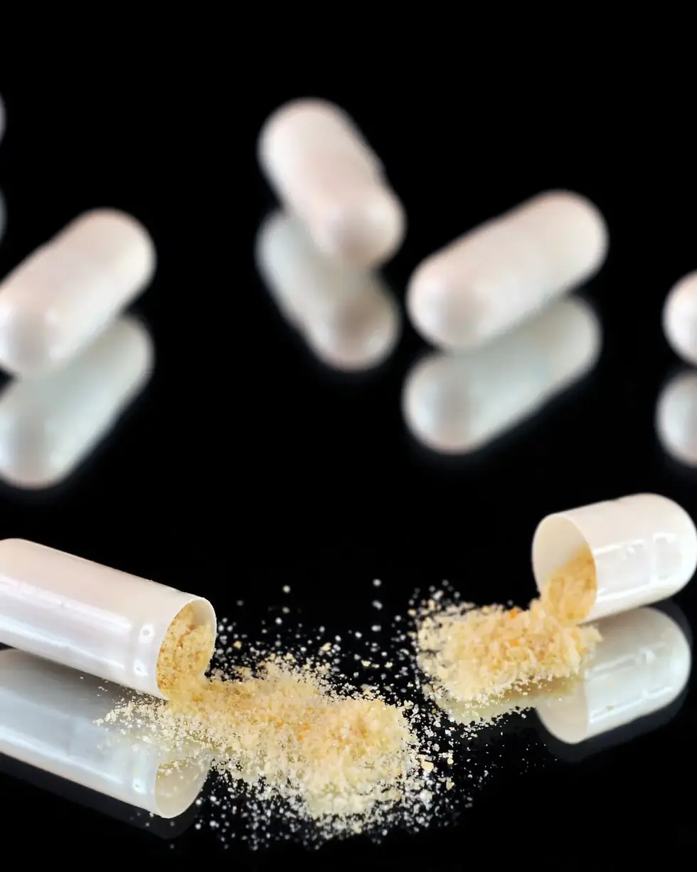 Open capsules with powder coming out of them.