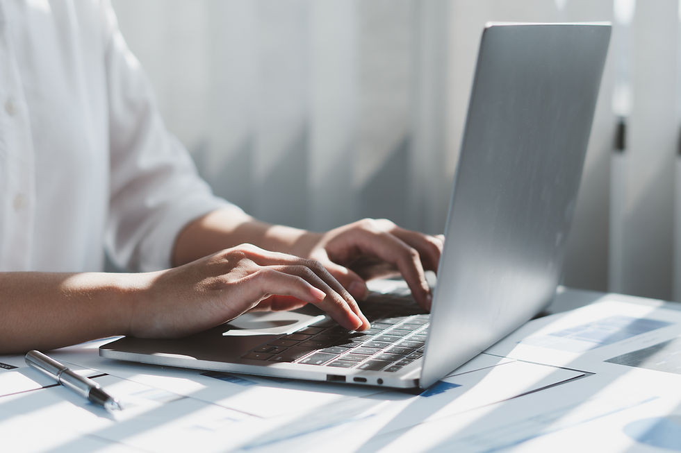 Accountant reviewing financial documents on a laptop with a calculator, representing QuickBooks Online AI bookkeeping