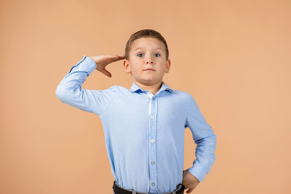 Boy very stiff at attention giving a salute with his right hand.