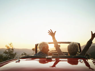 Seniors driving a car into the sunset