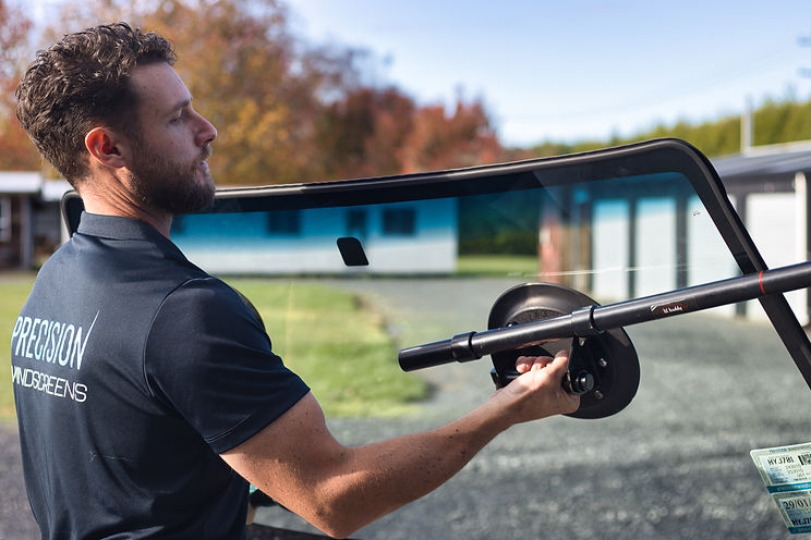Windscreen technician holding windscreen